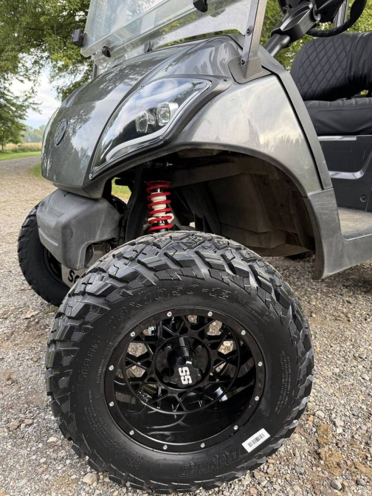 Lifted carbon 2021 Yamaha Drive2 EFI golf cart with black wheels, sold by Rugged Buggies, Byron, MI