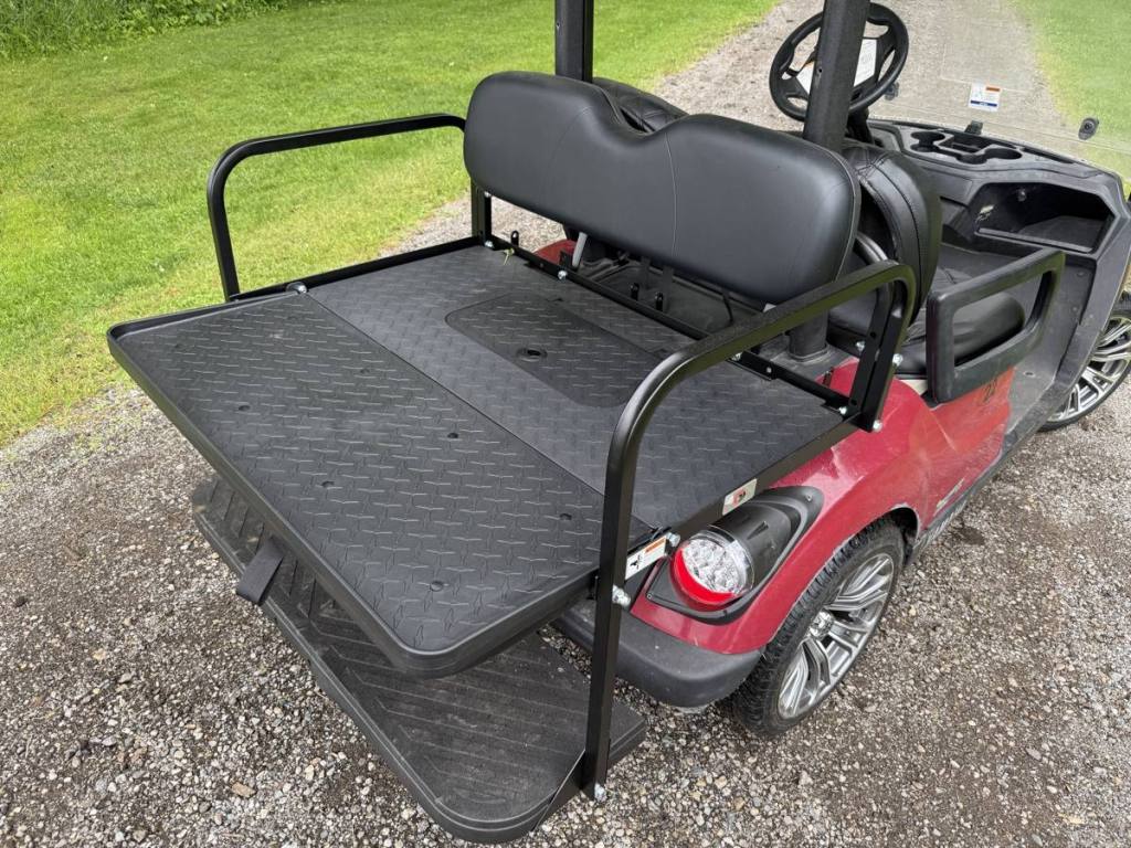 Golf cart rear flip seat kit folded flat as a cargo deck on a red Yamaha
